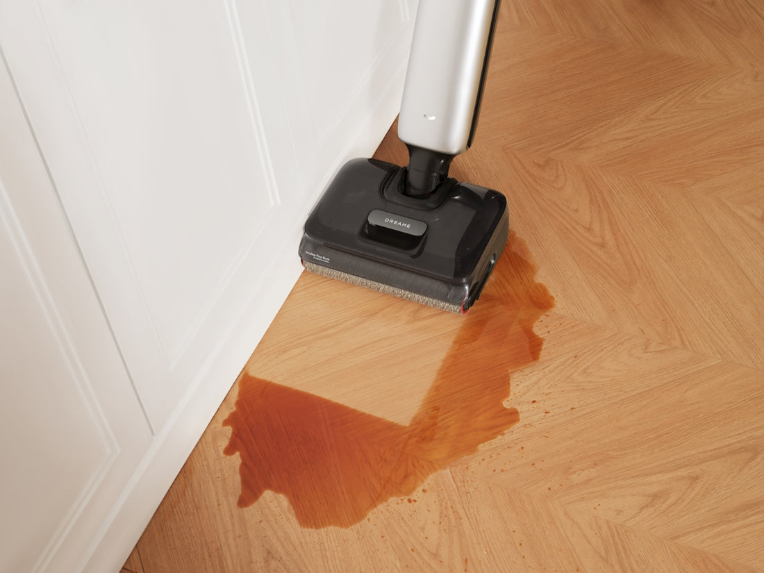 Vacuum cleaner cleaning a spill on a wooden floor