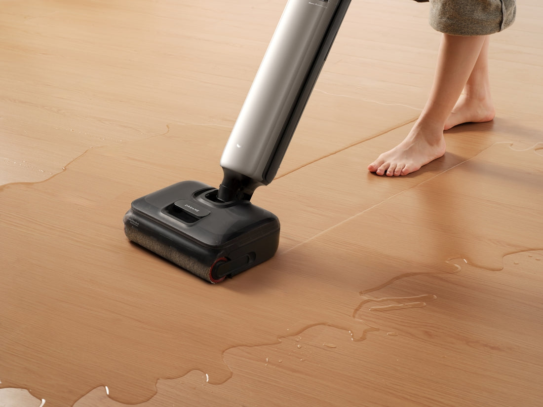Person vacuuming water from a wooden floor